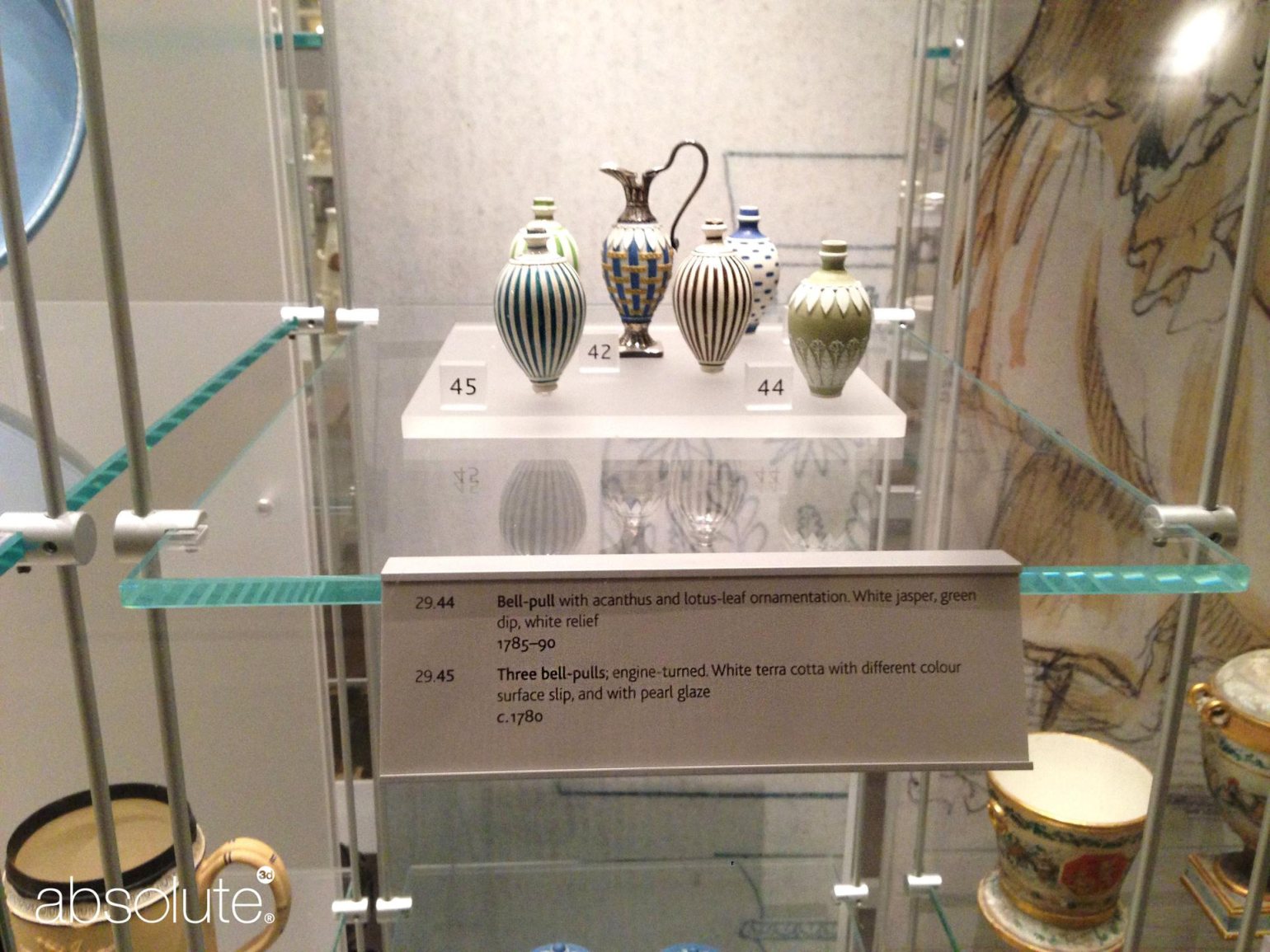 Antique ornaments in glass case and related information displayed on a shelf edge label holder. Antique ornaments in glass case and related information displayed on a shelf edge label holder.